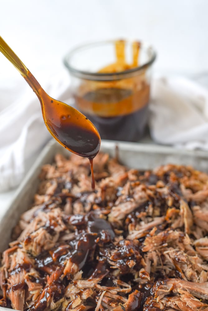 drizzling BBQ sauce on pulled pork