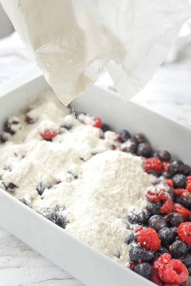 pouring cake mix over fruit