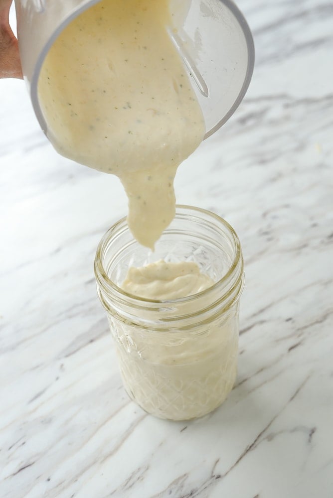 pouring salad dressing into jar