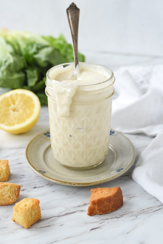 jar of caesar dressing with a spoon in it