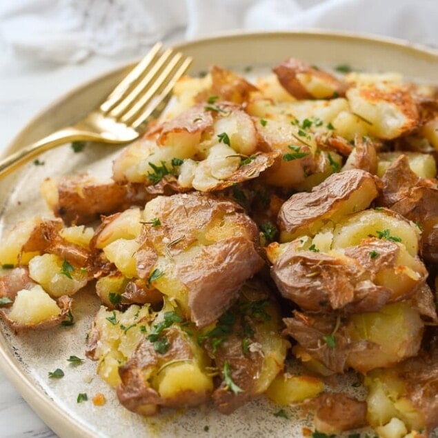 plate of smashed potatoes and a fork