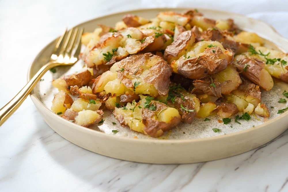 plate of smashed potatoes with a fork