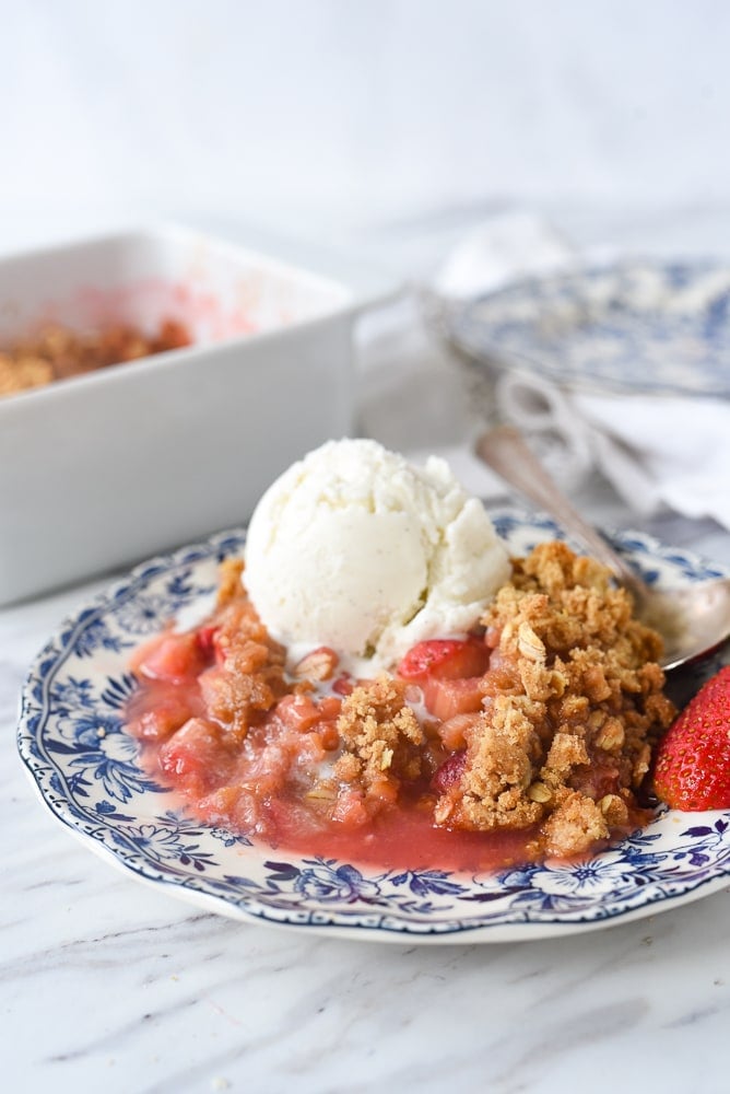 plate of strawberry rhubarb crisp with ice cream