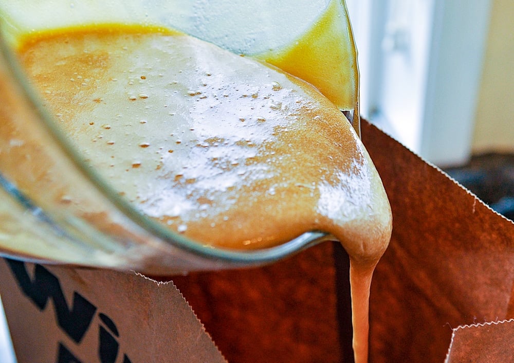 pouring caramel corn mixture into bag