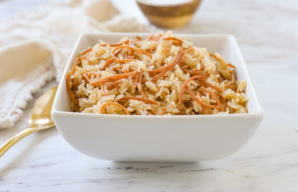 white bowl of rice pilaf with a spoon