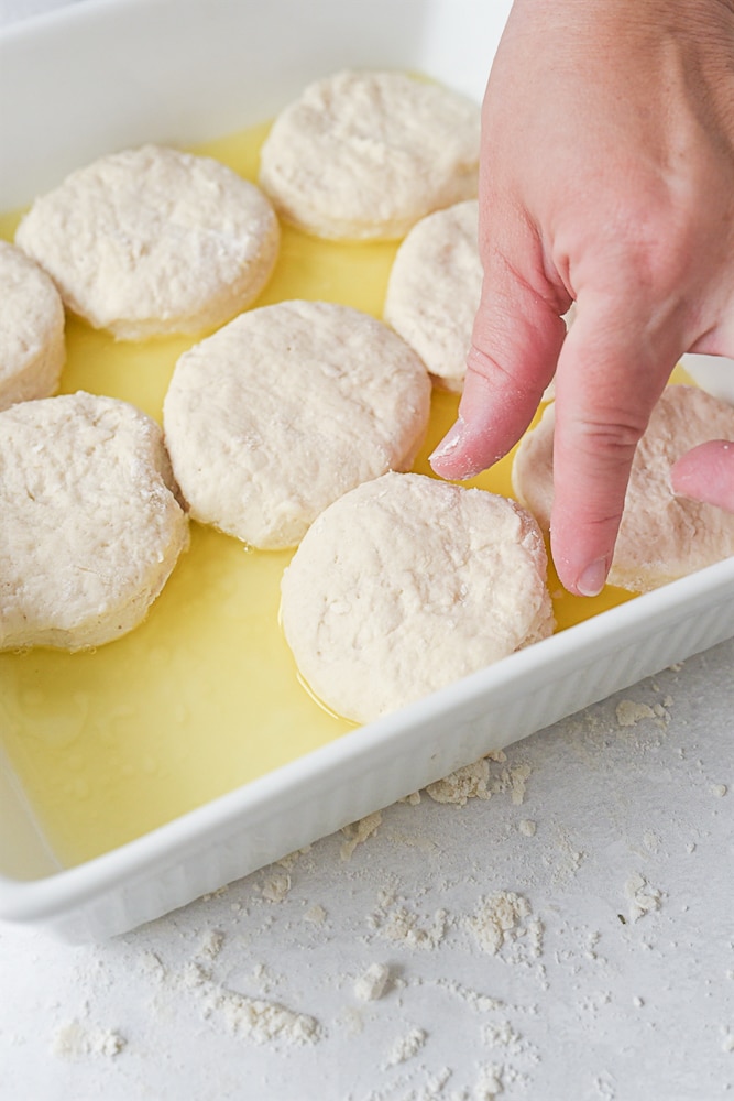 placing biscuit into butter