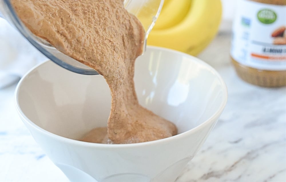 pouring chocolate almond milk smoothie into bowl