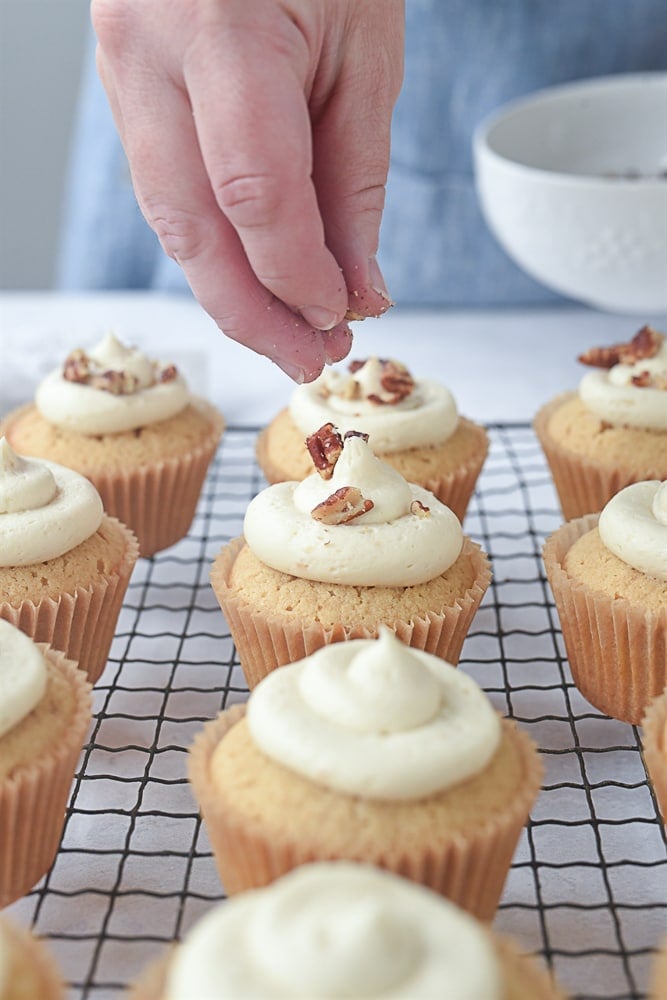 sprinkling cupcakes with pecans