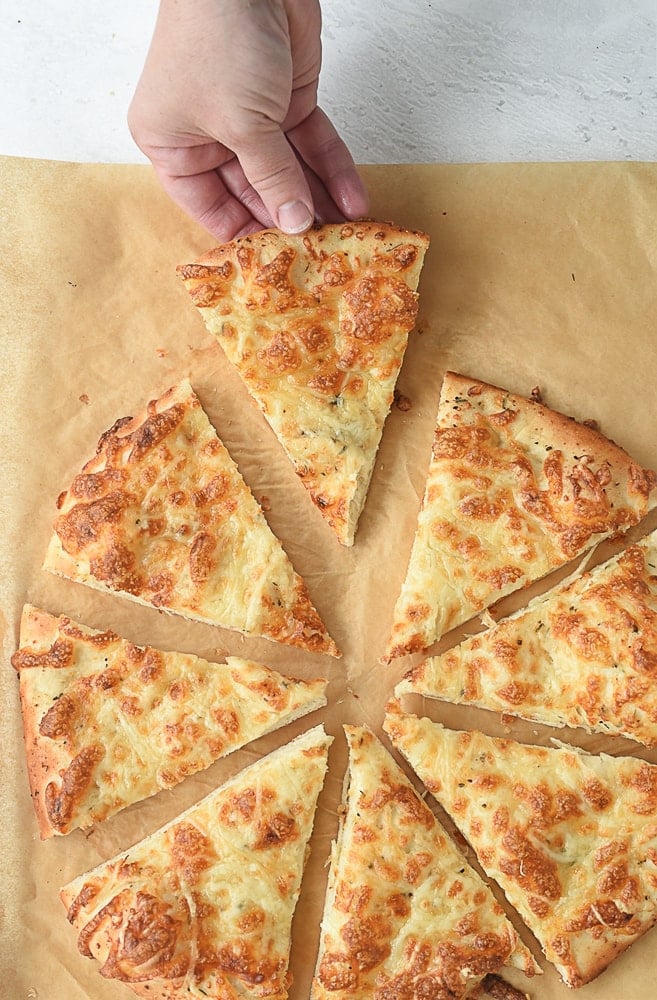 Cheesy Bread hand holding a piece of cheesy bread