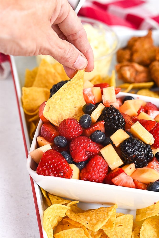 chip dipping into fruit salsa.