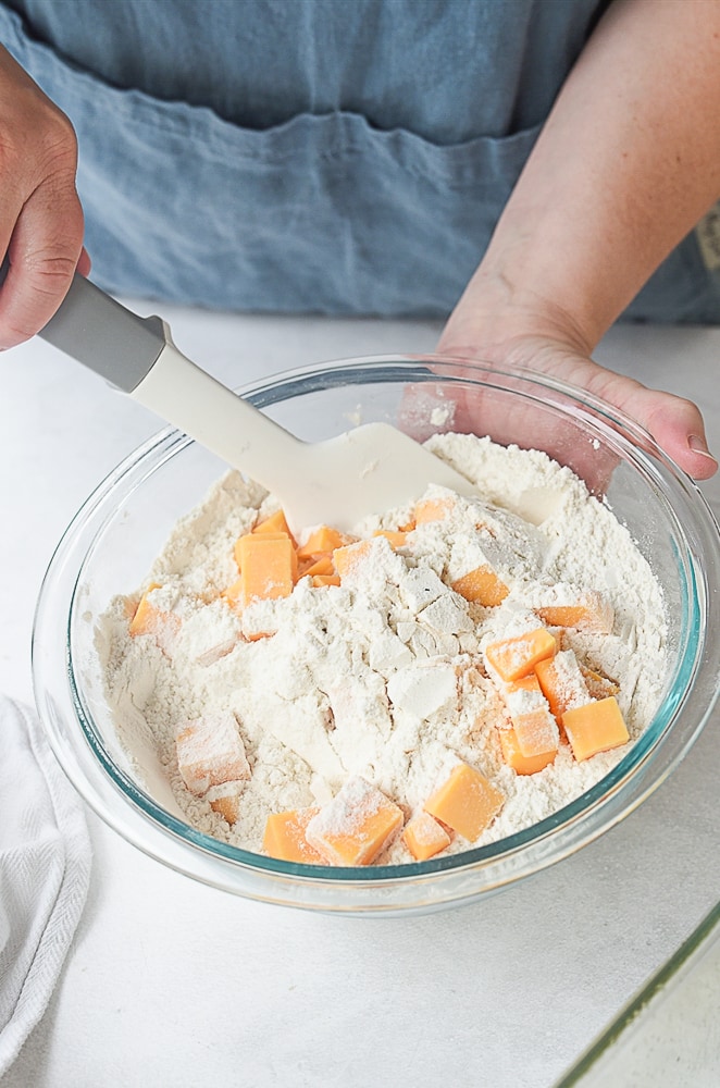 adding cubed cheese into bread
