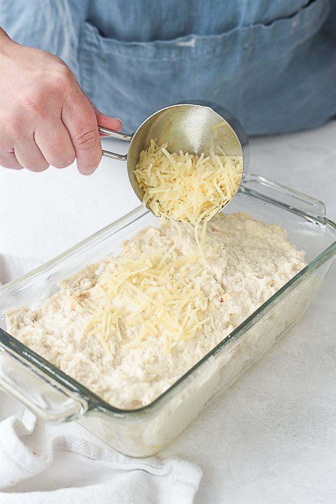 sprinkling cheese on top of bread