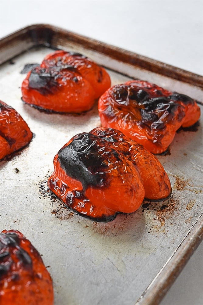 charred red pepper on a baking sheet