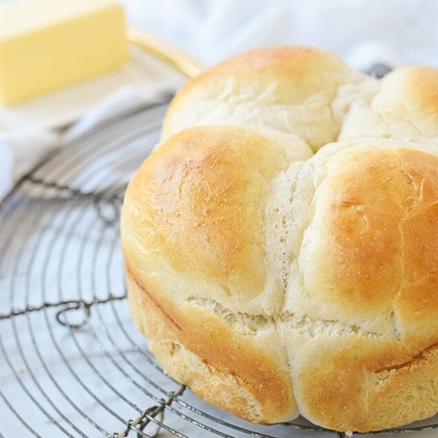 four dinner rolls on a cooling rack