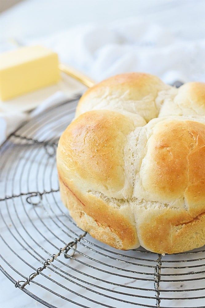 four dinner rolls on a cooling rack