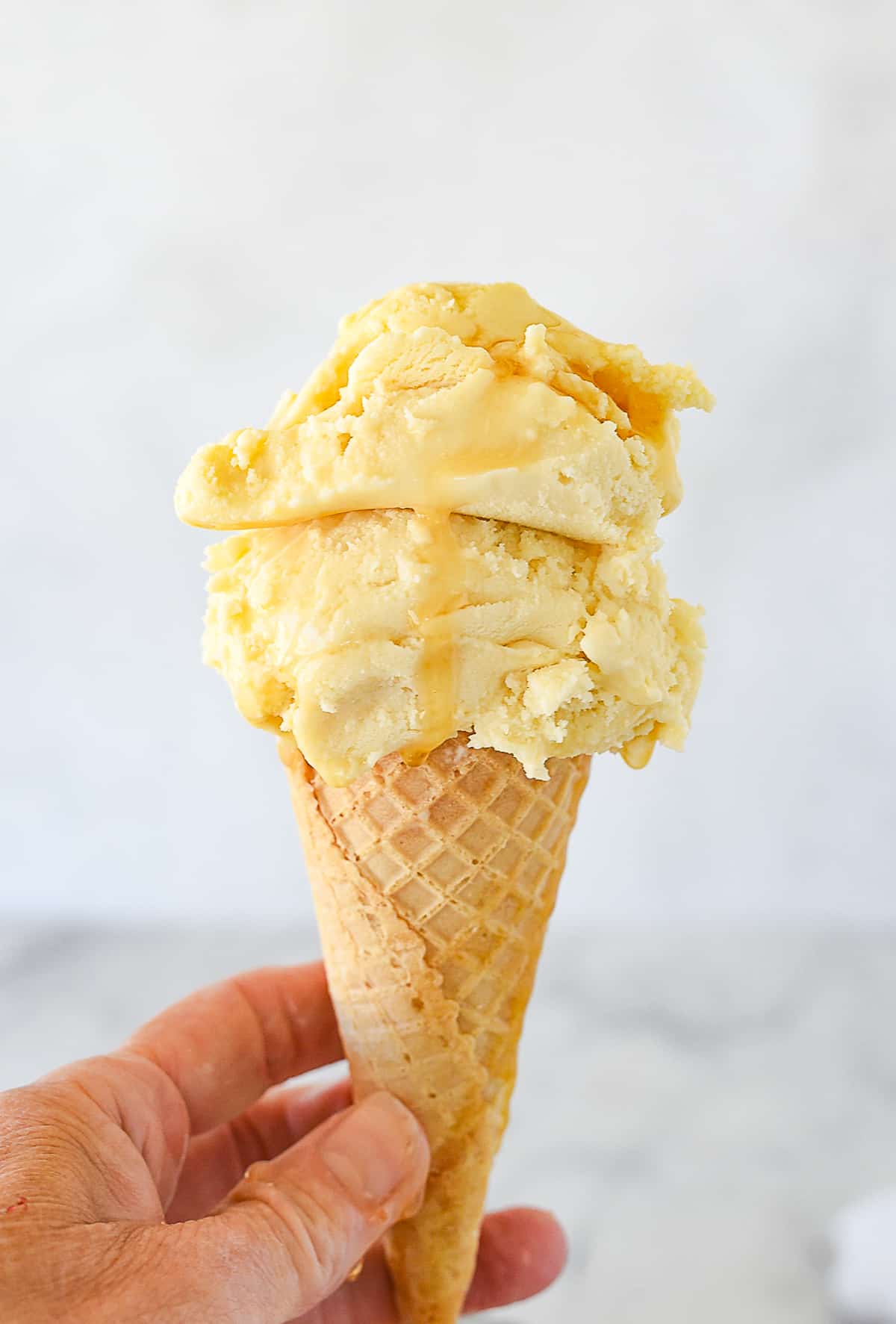 hand holding a maple ice cream cone
