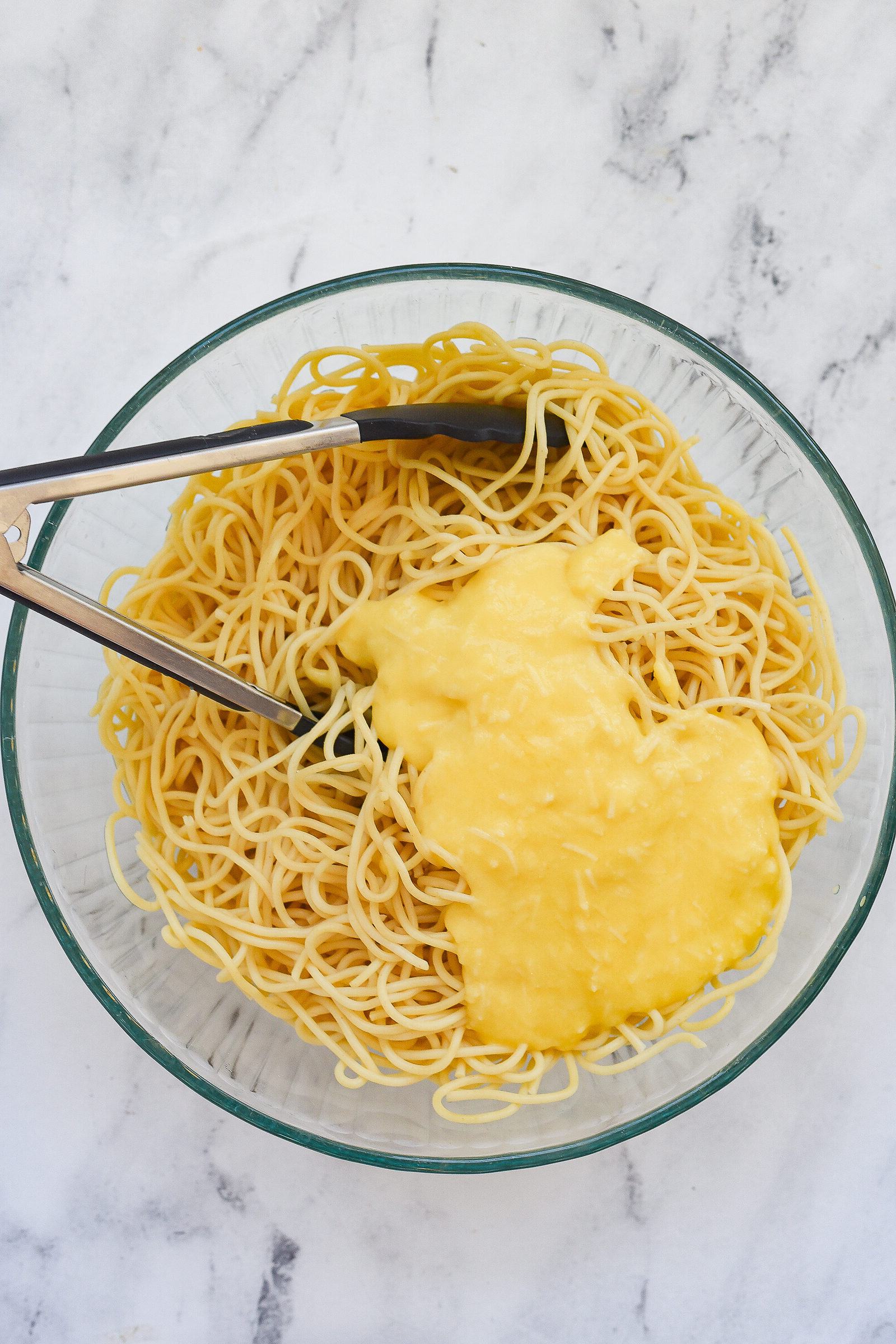 mixing noodles with egg mixture