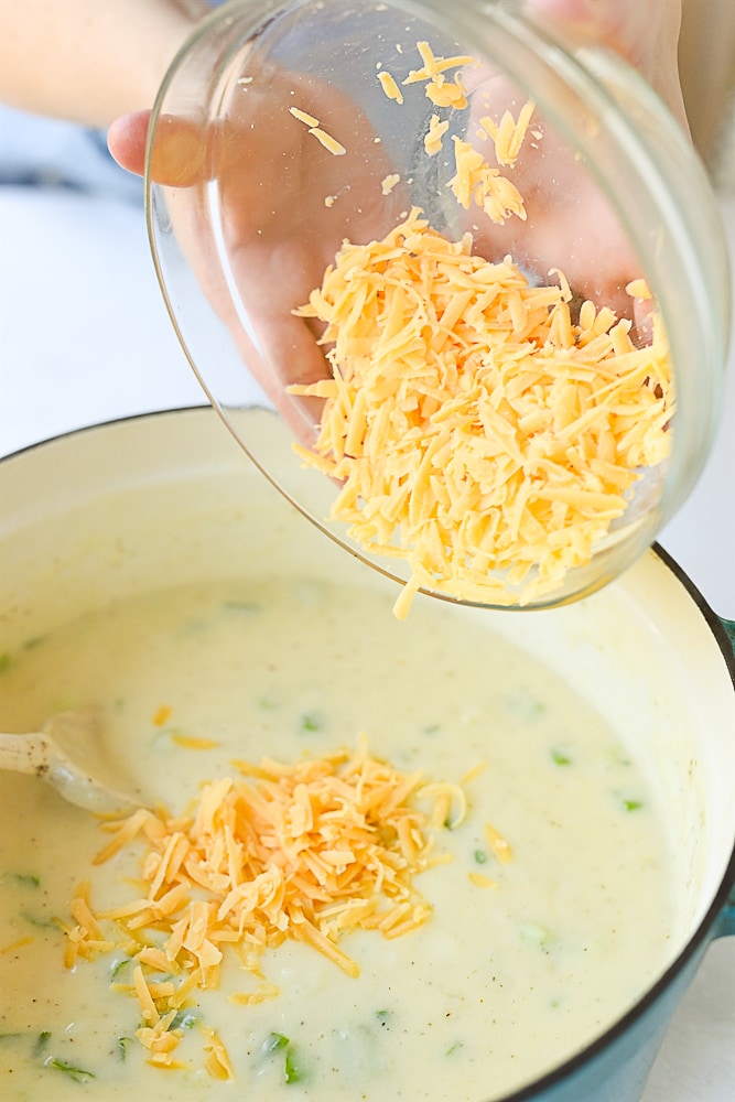 adding cheese into soup