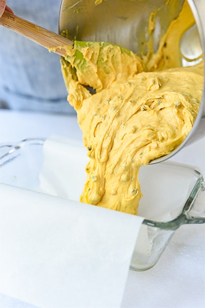 pouring pumpkin bread batter into pan