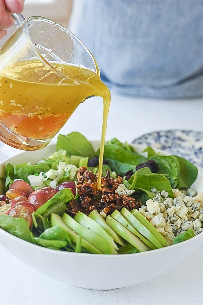 pouring salad dressing on salad