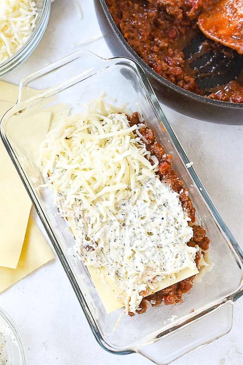 spreading cheese on lasagna