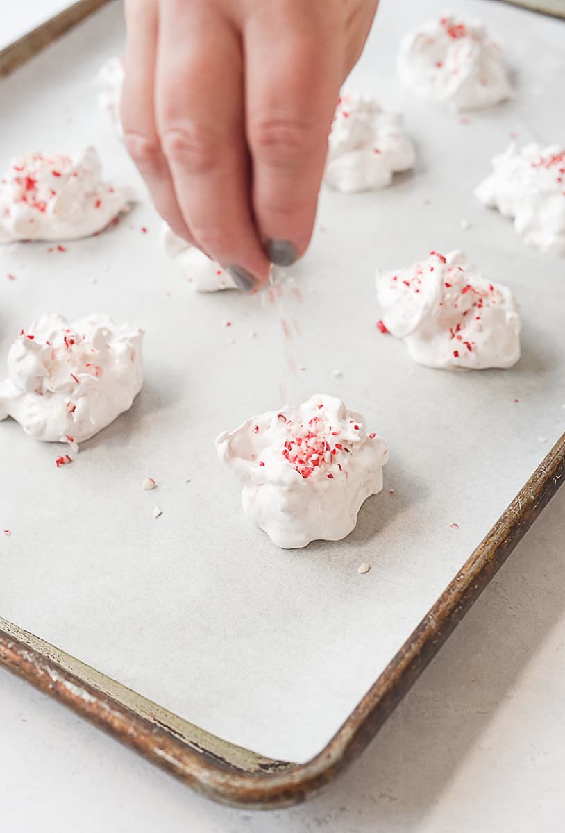 sprinkling candy cane onto meringues