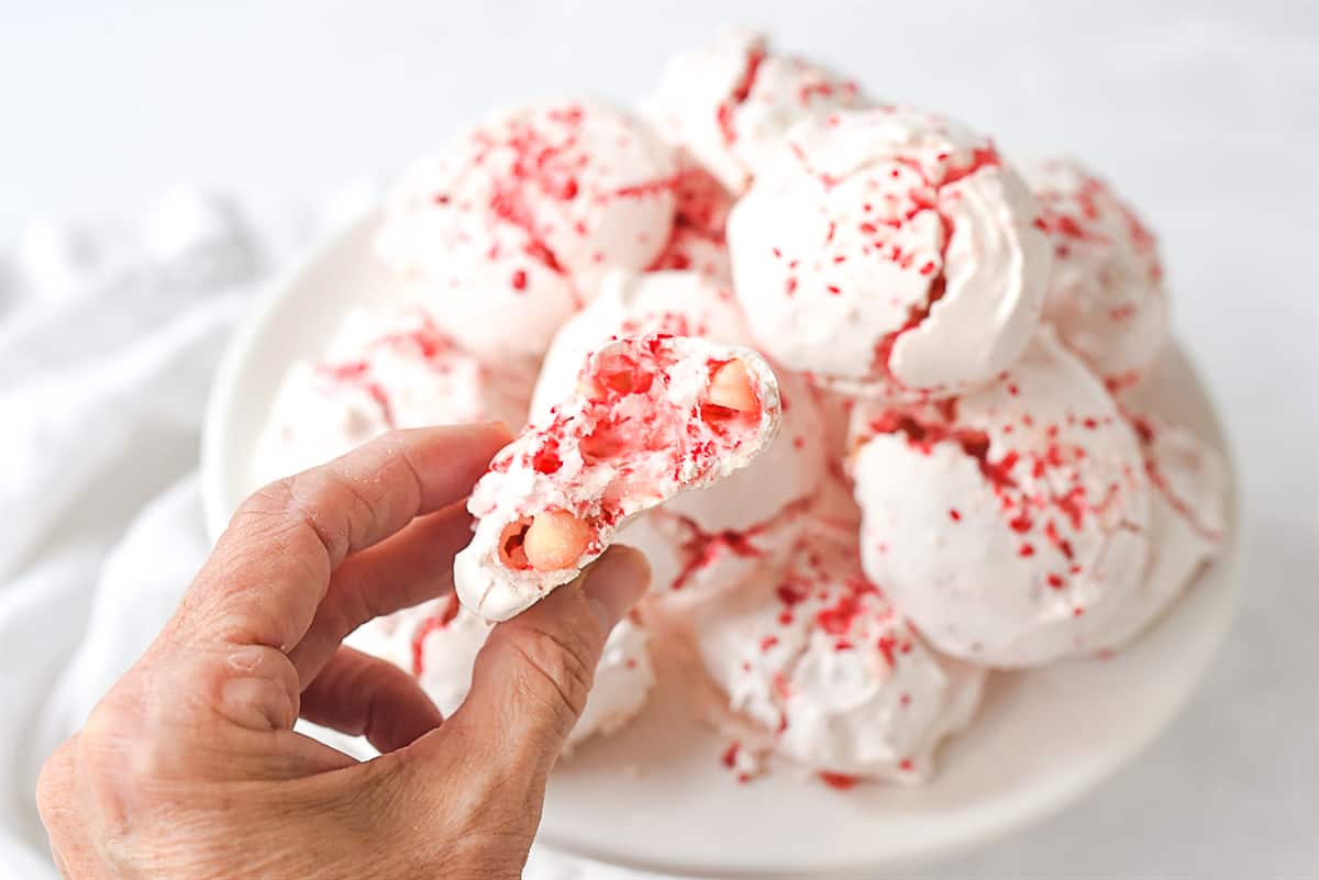 hand holding a peppermint meringue