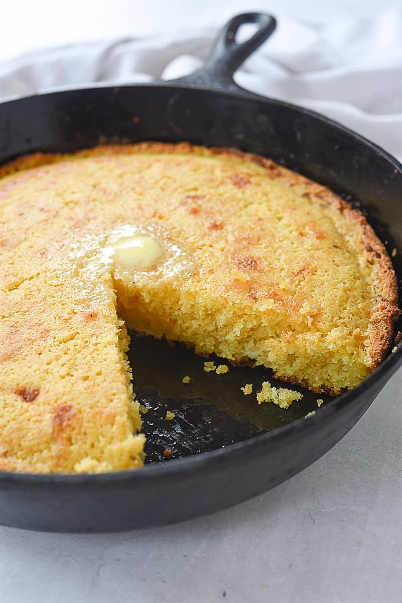 cornbread in a skillet with piece missing