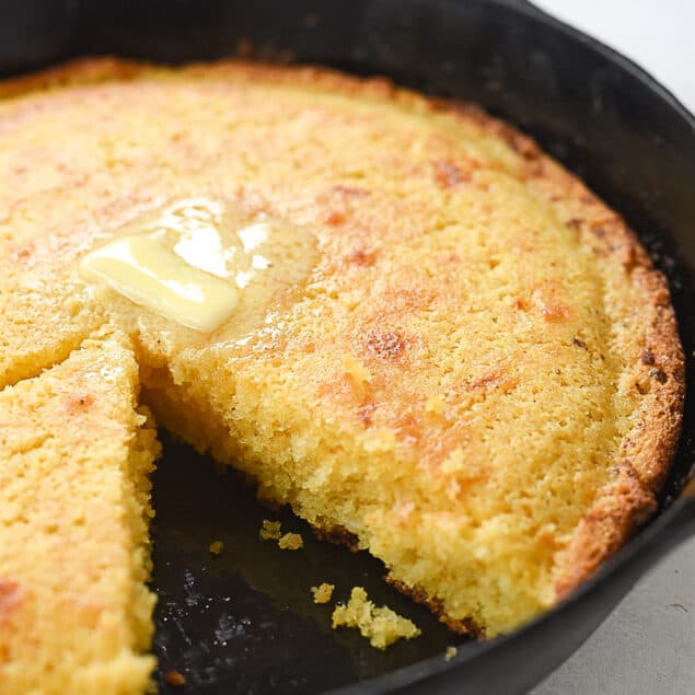 cornbread in a skillet with a piece missing