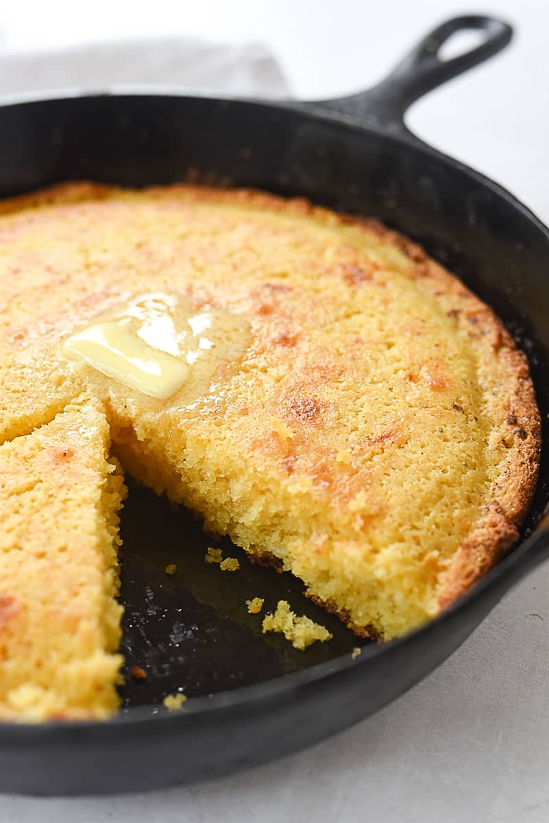 cornbread in a skillet with a piece missing