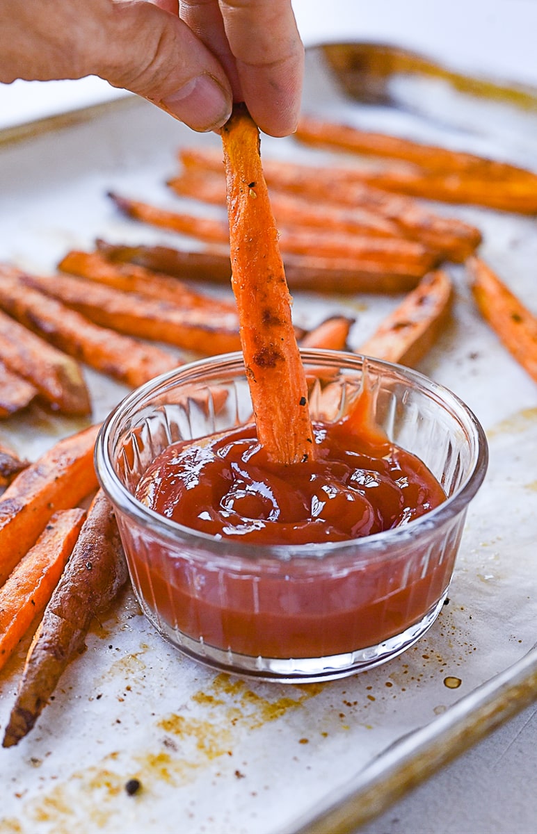 dipping sweet potato fry in ketchup