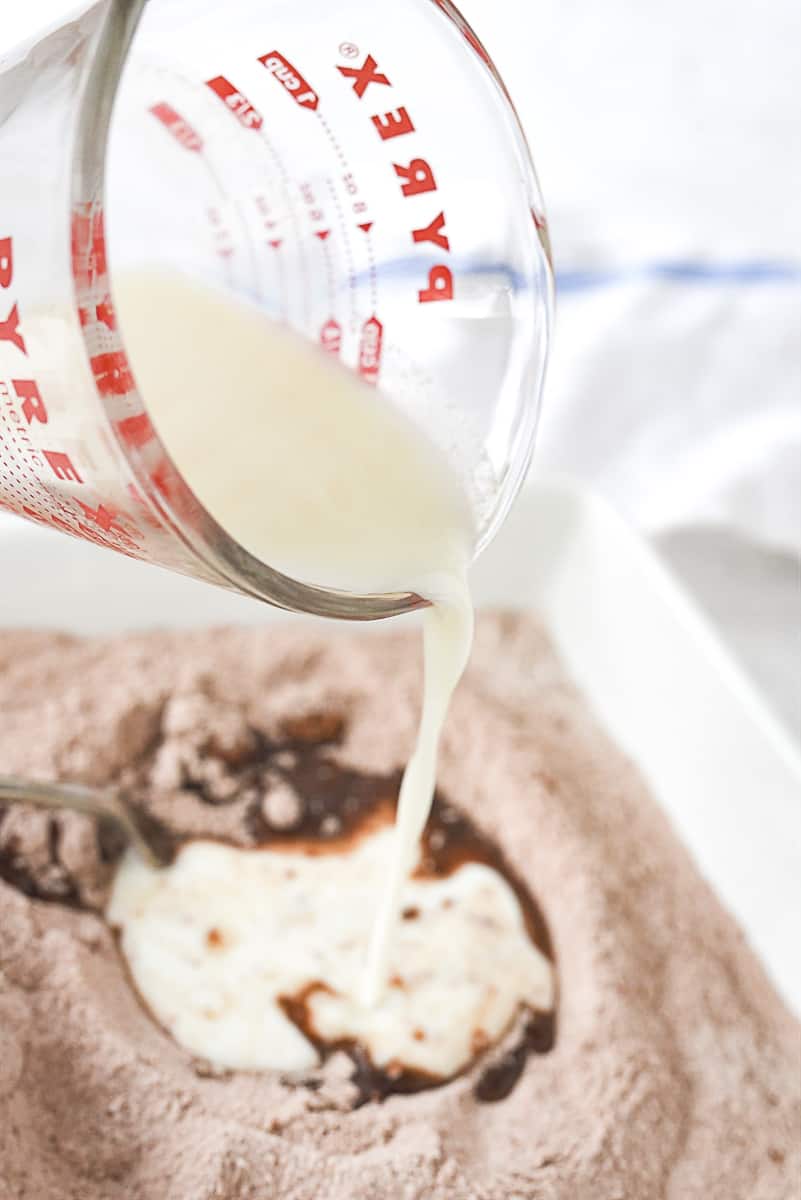 pouring milk into hot fudge cake batter