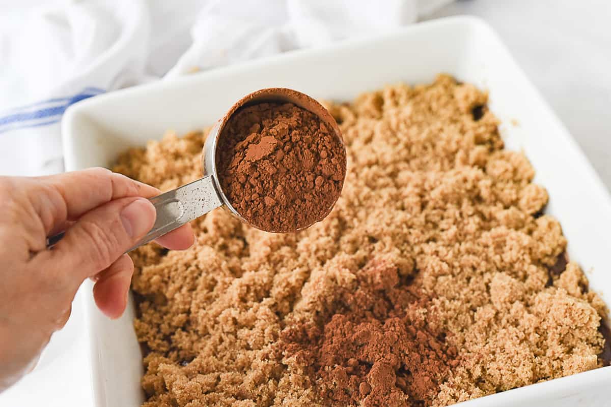 sprinkling cocoa onto hot fudge sunday cake