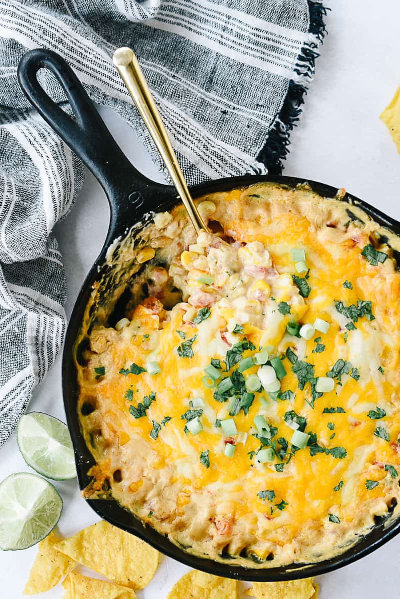 overhead shot of hot corn dip with a spoon in it
