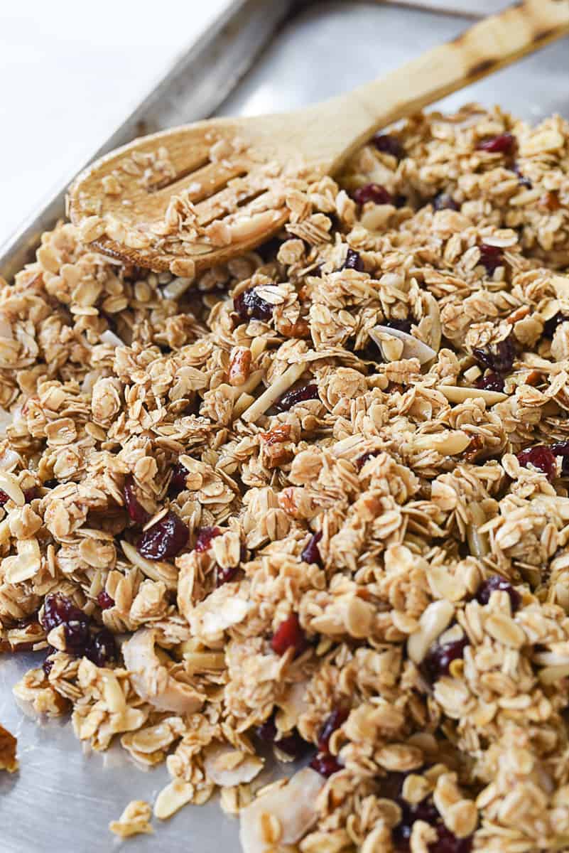 spreading granola on baking sheet