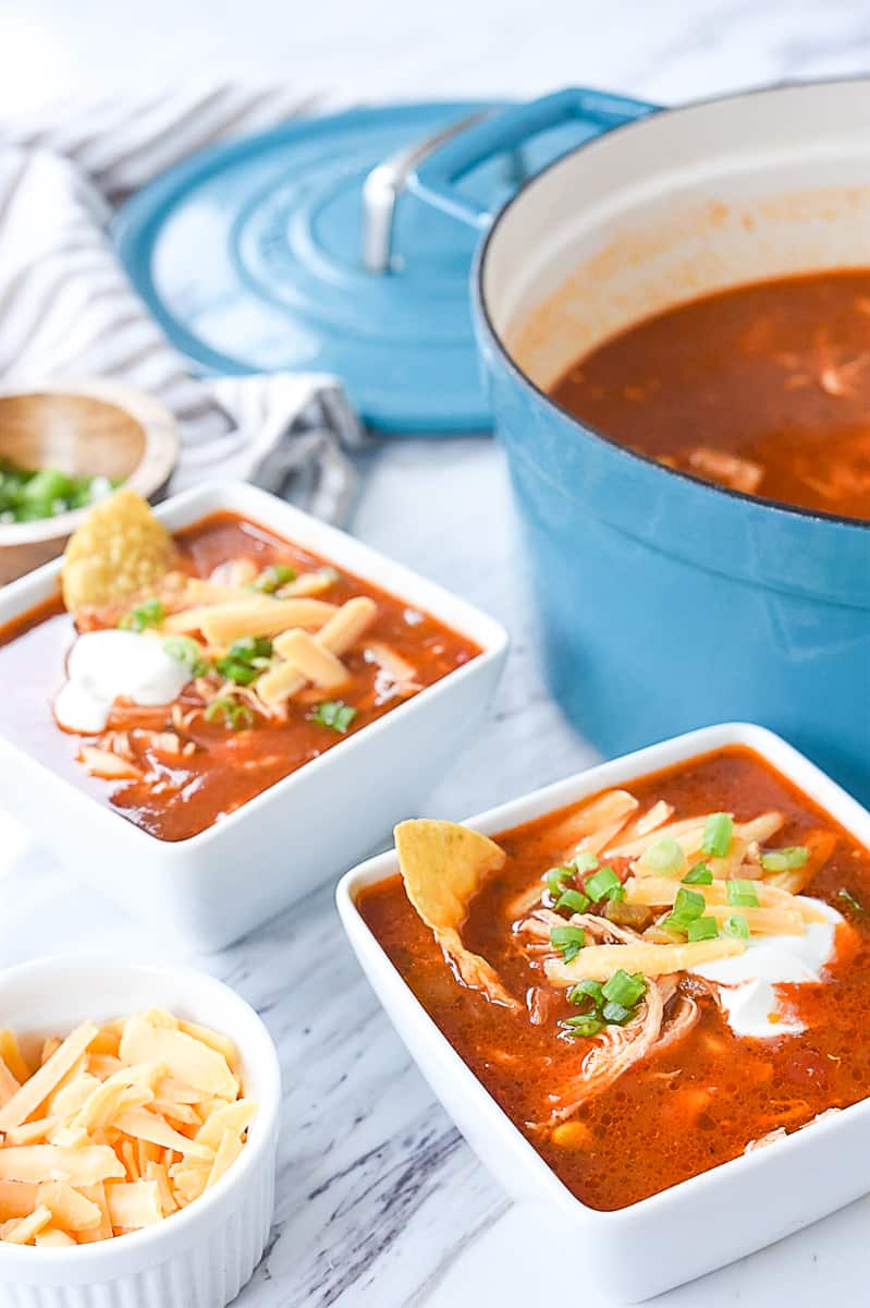 two bowls of soup with cheese on top