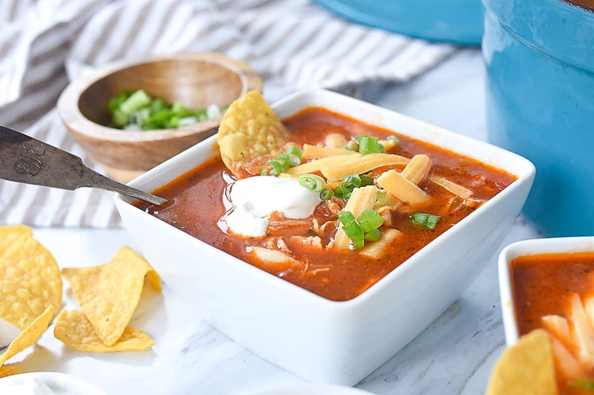 chicken enchilada soup with sour cream on top