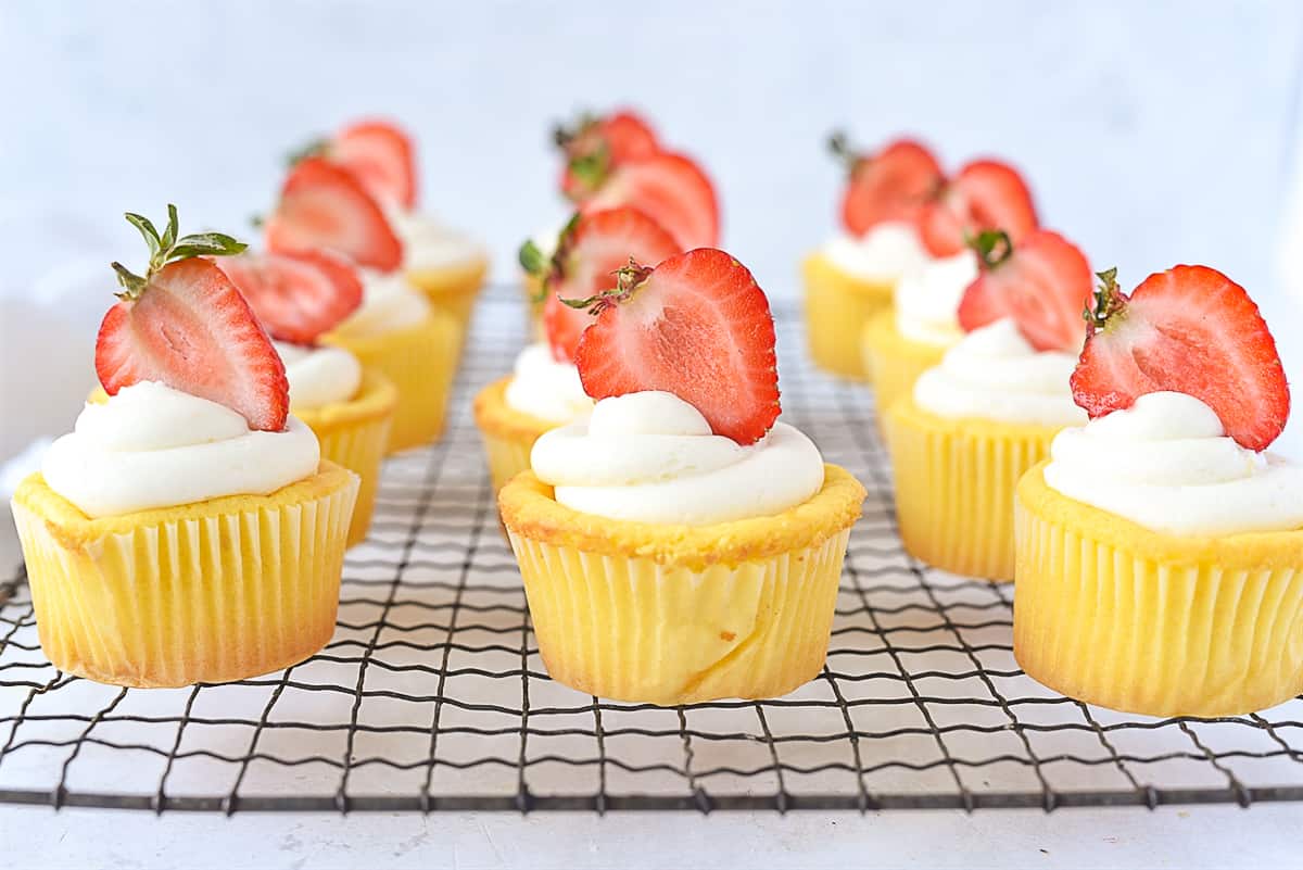 row of lemon cupcakes with white frosting