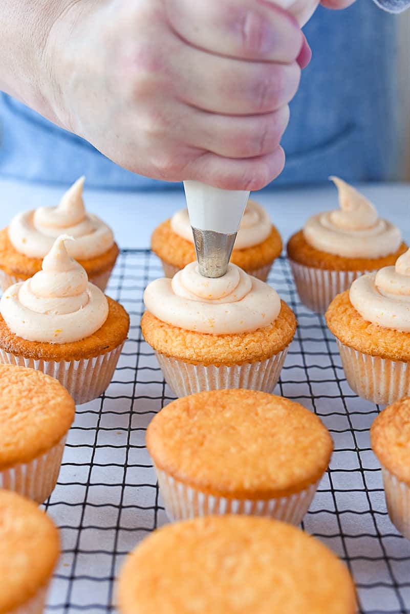 Frosting orange cupcakes