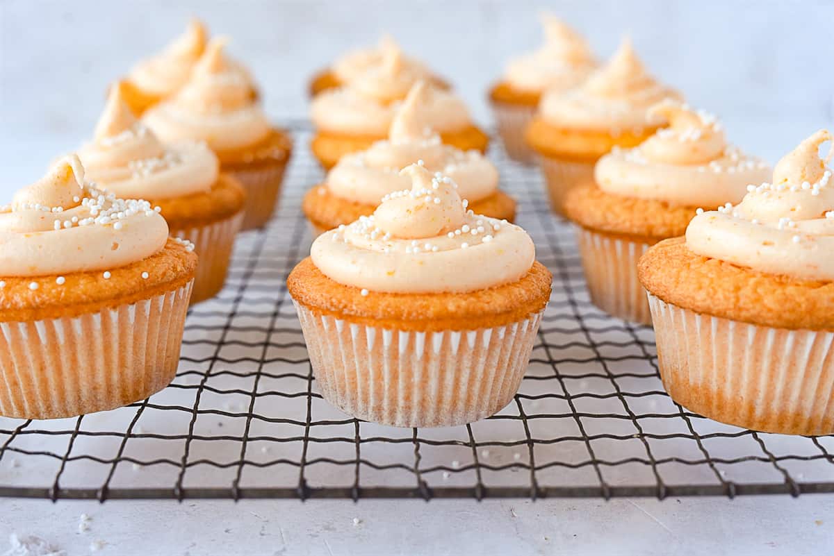 rows of orange cupcakes on a rack