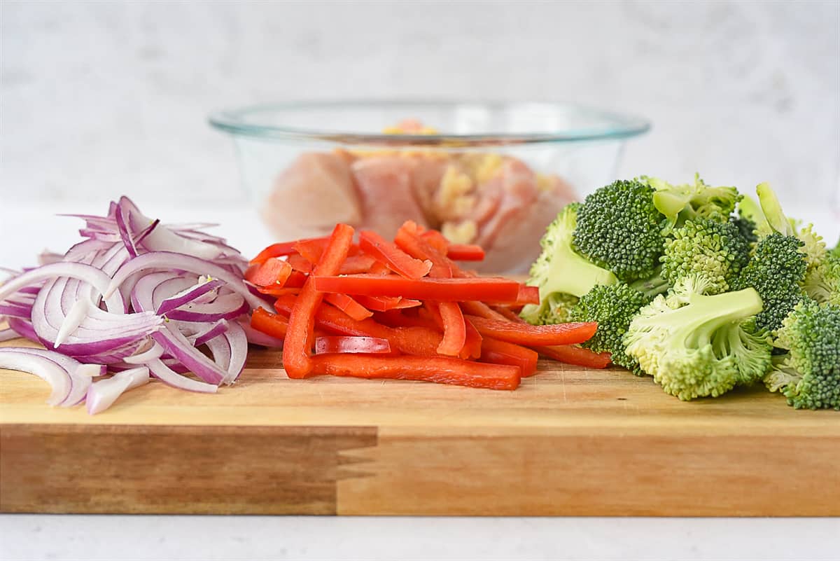 onions peppers and broccoli on a cutting board