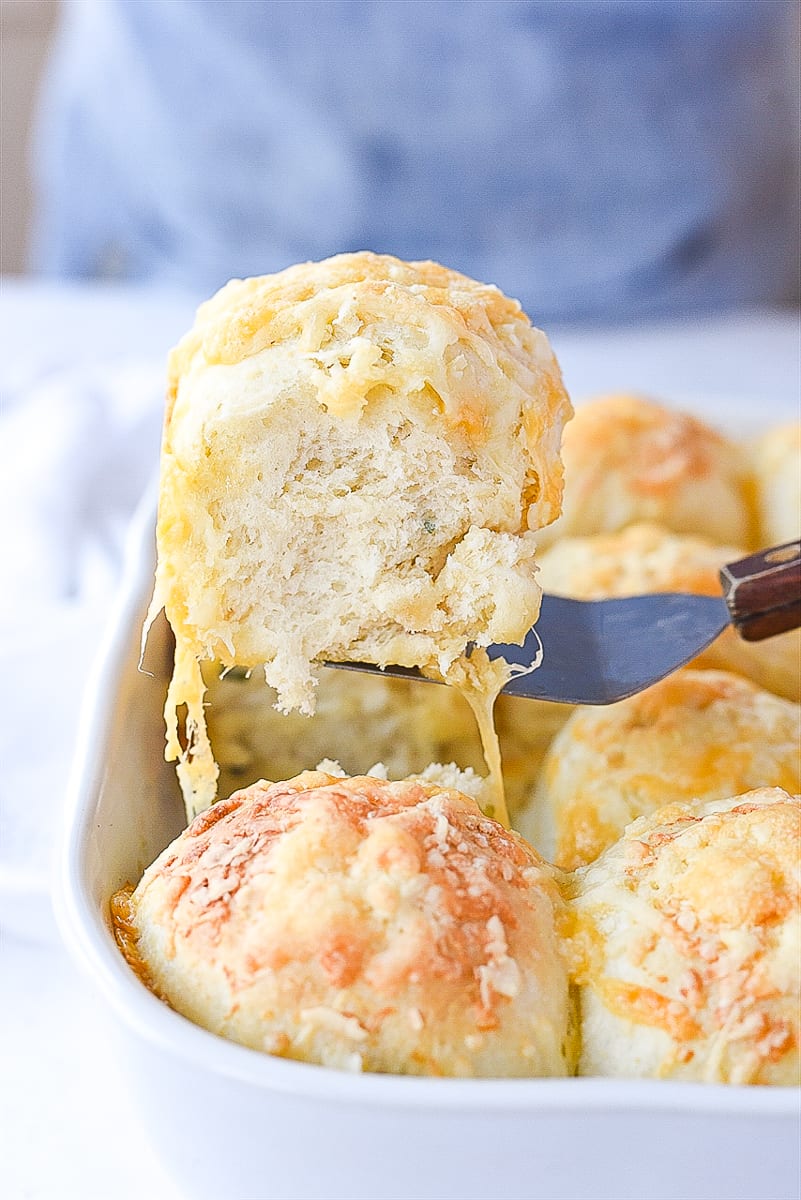 lifting a cheese herb roll out of the pan