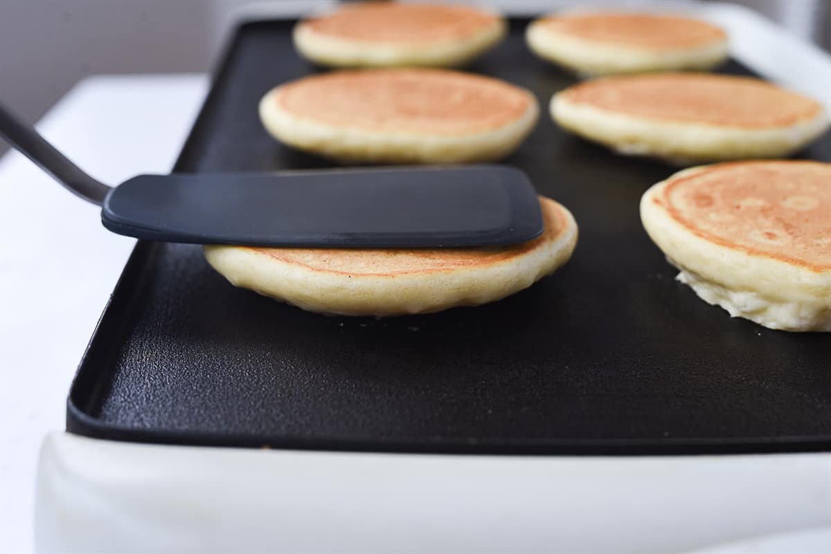 pressing down a pancake with a spatula
