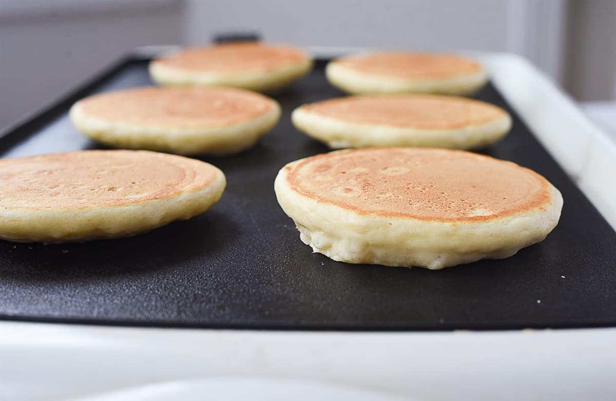 pancakes cooking on a griddle