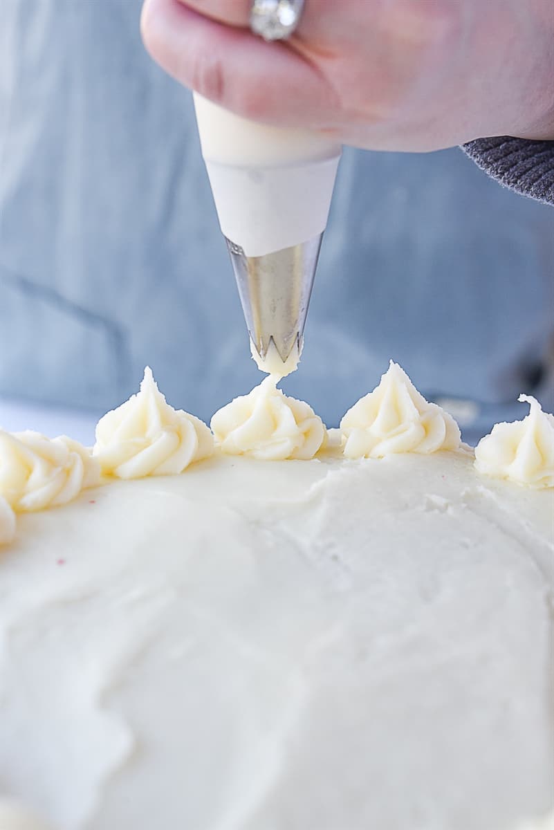 garnishing red velvet cake with frosting