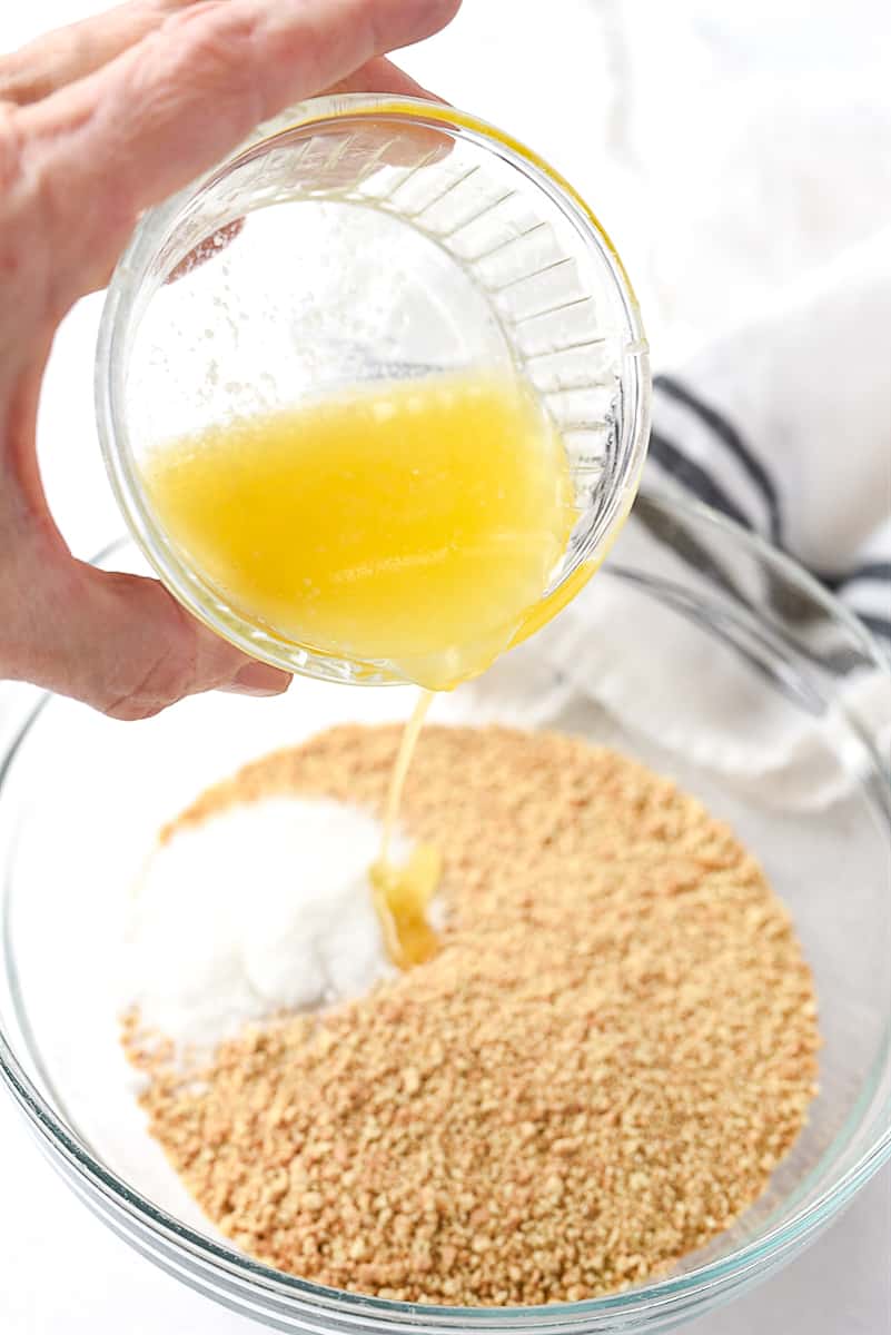 adding butter into graham cracker crumbs.