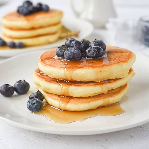 stack of three pancakes with blueberries on top