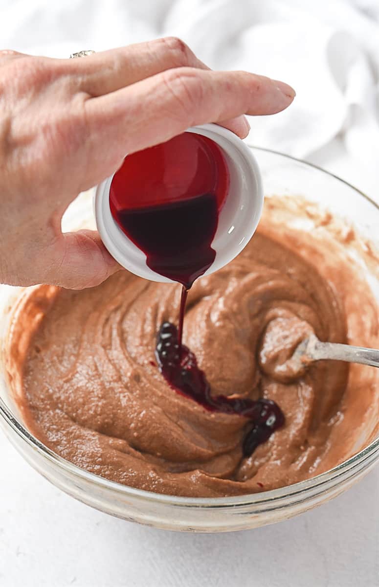 adding in red food coloring to red velvet cake