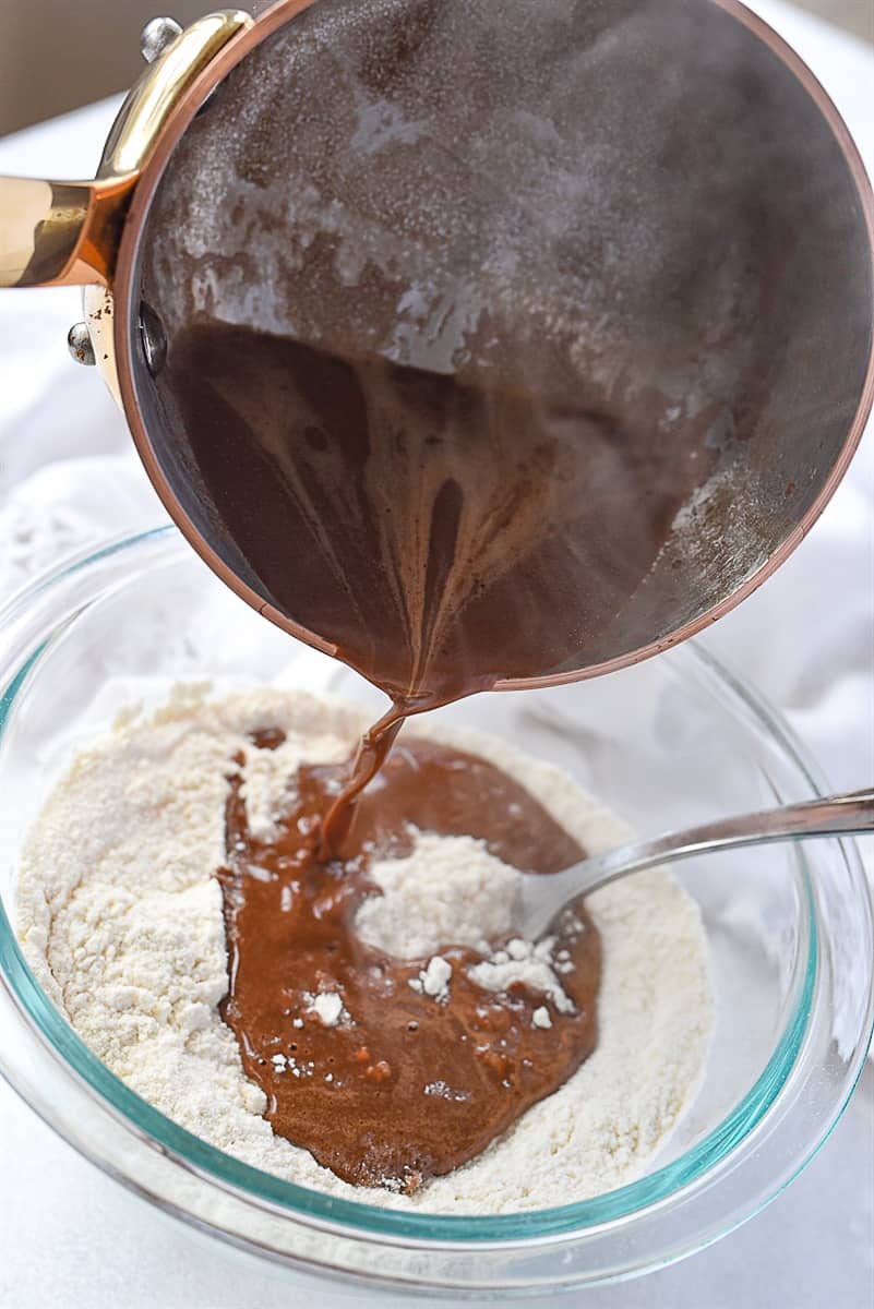 pouring chocolate mixture over flour mixture
