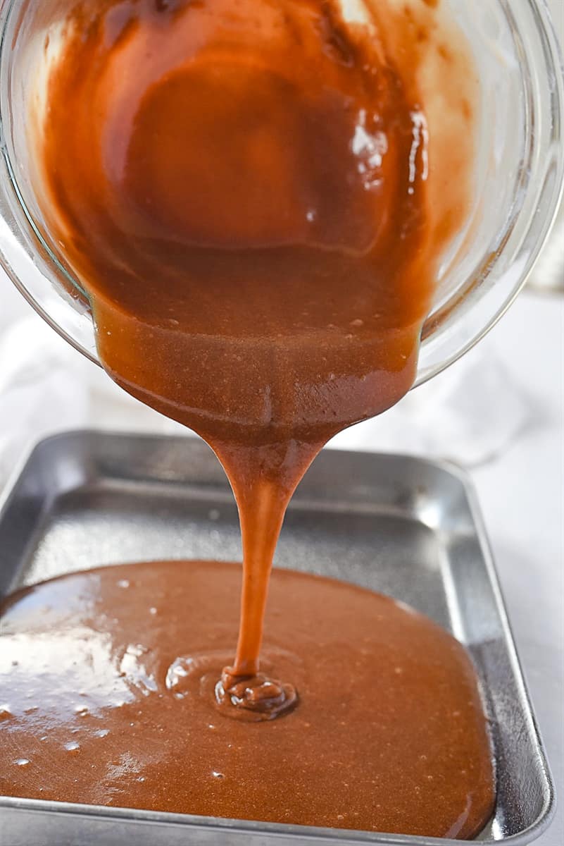 pouring chocolate sheet cake batter into pan